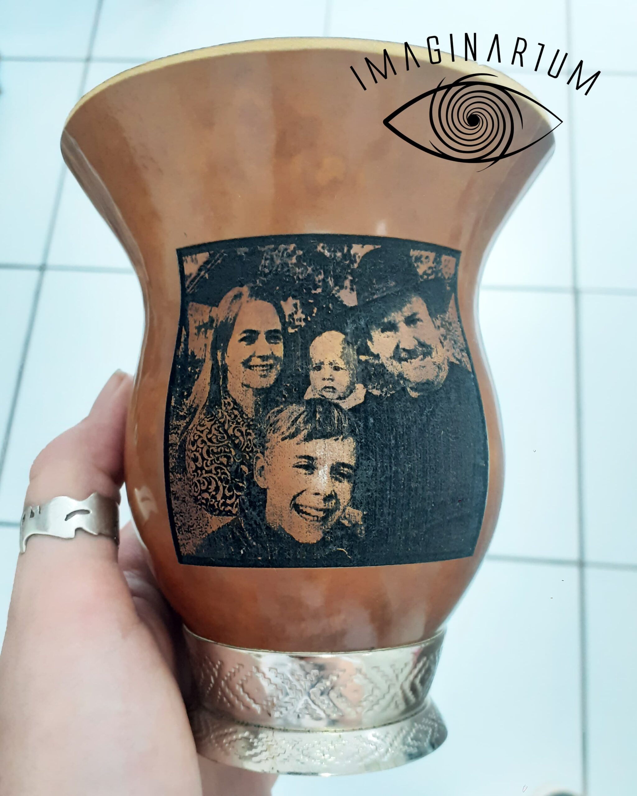 Cuia de chimarrão personalizada com foto de família, fundo de casa atrás, mulher sorrindo e segurando uma criança, menino sorrindo, homem sorrindo de chapéu