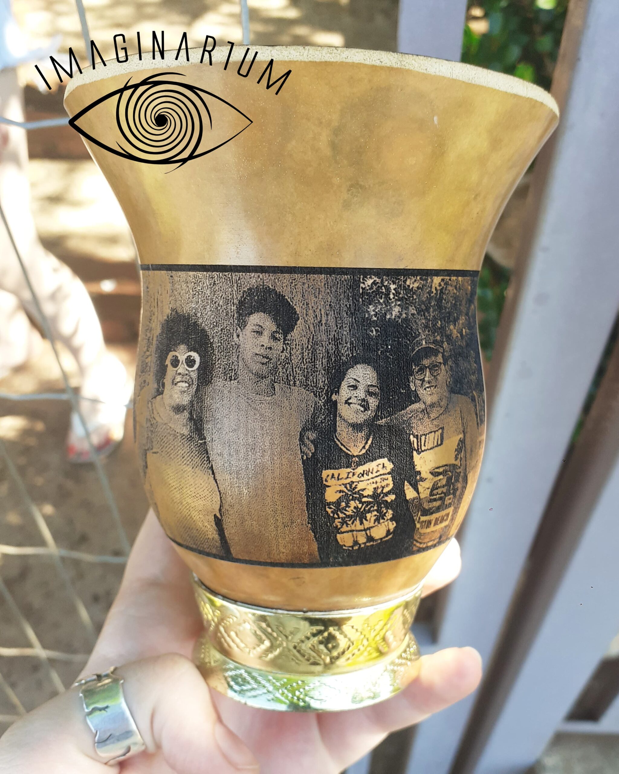 Cuia de chimarrão personalizada com foto de quatro amigos abraçados, ao ar livre com fundo de árvores, incluindo mulher com óculos, menino, menina sorrindo e homem de boné